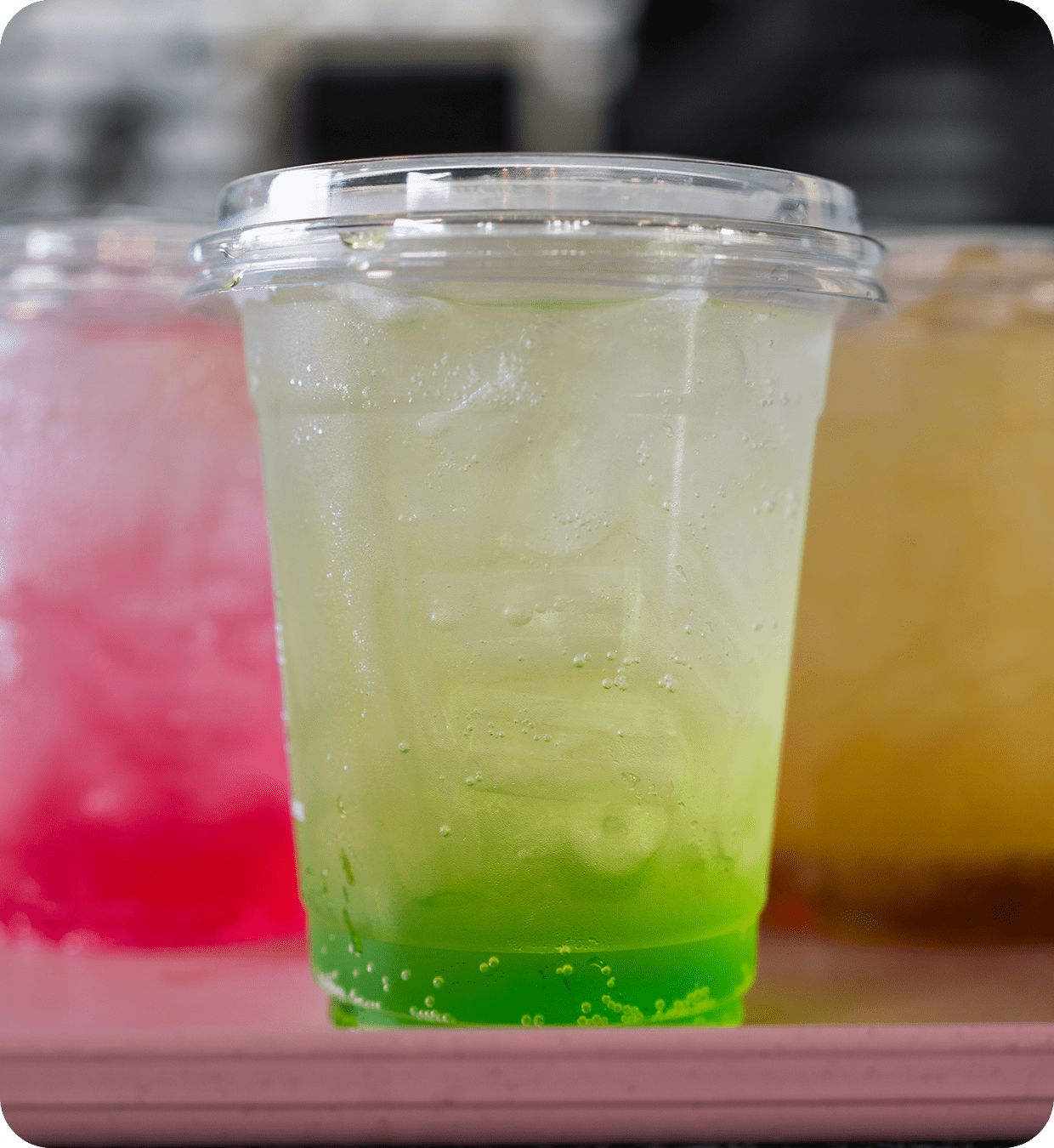 Green iced drink in clear plastic cup
